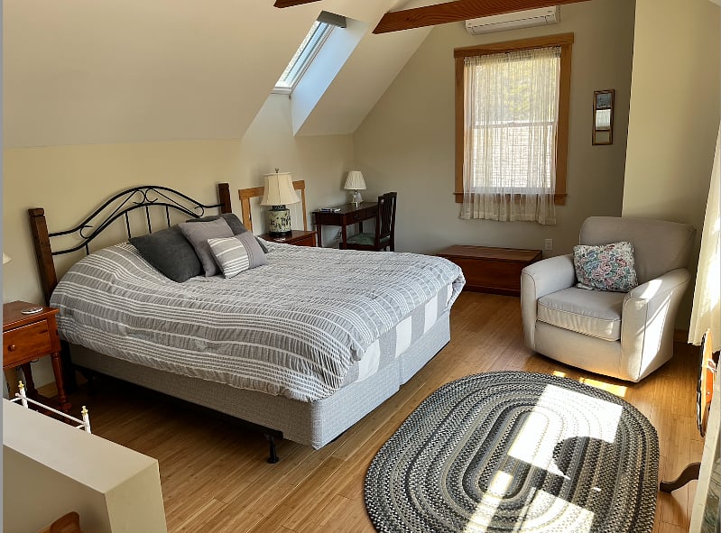 View of bedroom that also shows desk.  Access to eaves (for storage) behind the nightstand