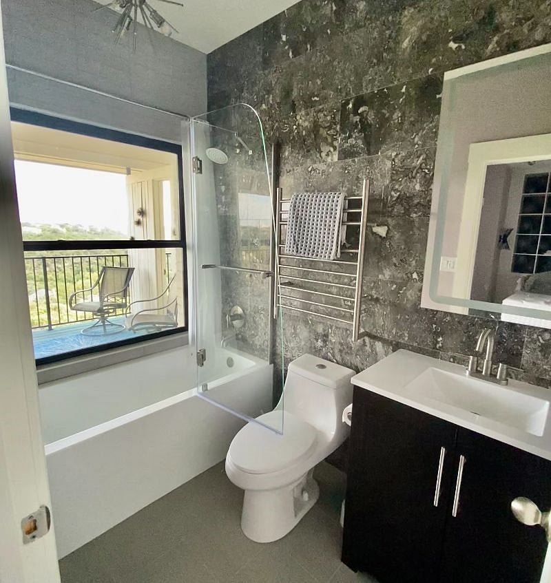 Luxury bathroom with tub/shower, towel warmer and LED lighted mirror. Enjoy the view through the picture window of the hills and sky with total privacy (except for the birds!)