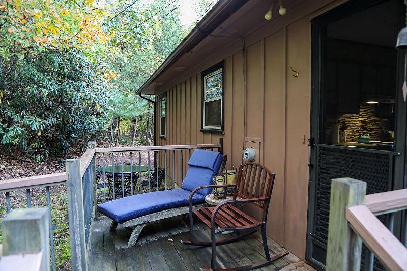 Wooded back deck with lounge chairs and dining table make it the perfect spot for an outdoor lunch, or possibly a nap!