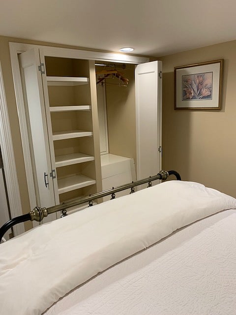 Closets at end of bed with doors opened