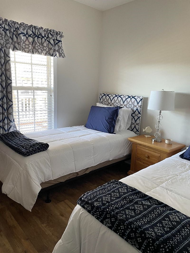 Twin bedroom with 2 twin beds, blinds and room darkening curtain.