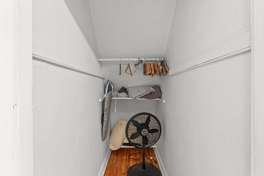 Full size closet with hangers, iron board, extra blankets and fan.