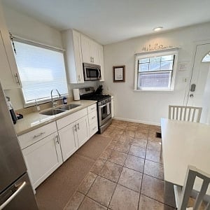 Kitchen with microwave, stove, refrigerator and table for 2