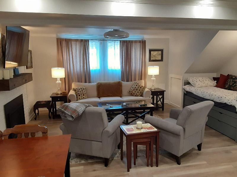 View of living room and kitchen table with chairs. On the left is the nook with Captains bed.
