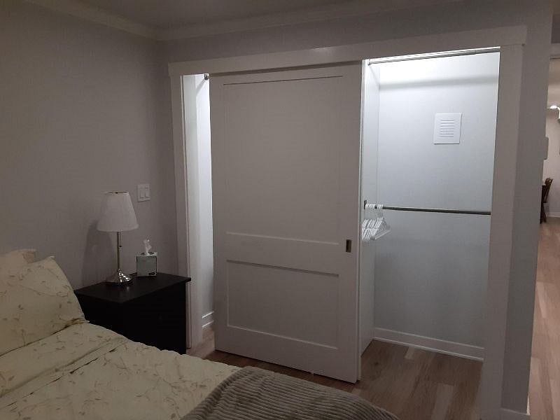 Bedroom closet with built in closet unit and deep storage.