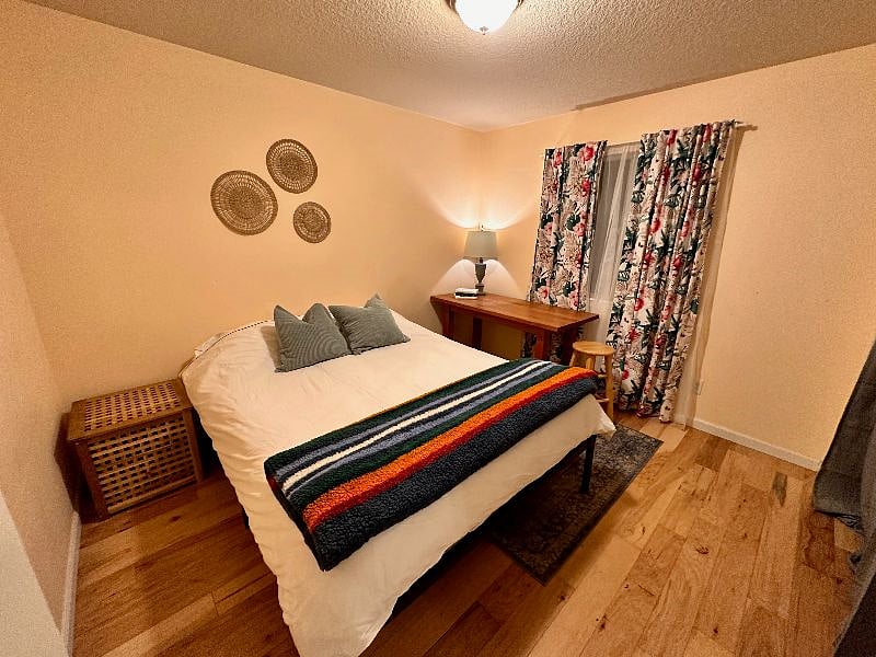 Side bedroom features a queen memory foam mattress and desk area. Other rooms are separated by a laundry room and kitchen, so you'll be sure to have privacy. H