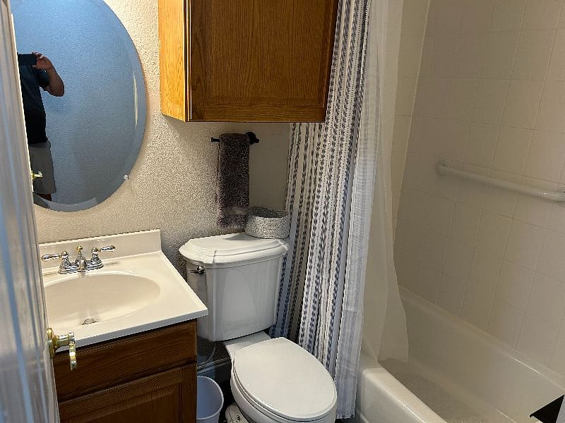 Small bathroom with tub, toilet, and sink/vanity.