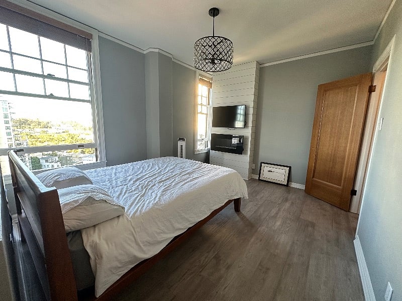Bedroom with view of TV, walk-in closet and city views