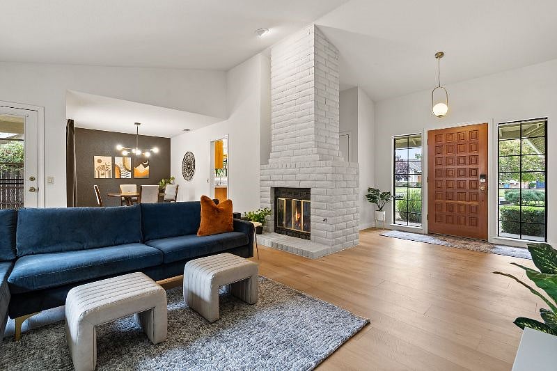 Open living space with soaring ceilings in the entry and living room, plus cozy fireplace.
