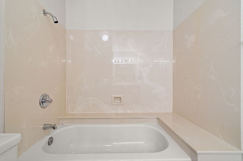 Hall bath with shower over tub and large shelves surround