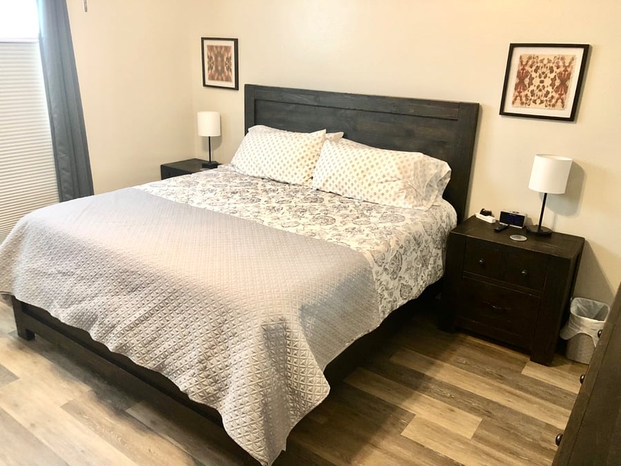 Primary bedroom with King bed, nightstands, chest, dresser, chest, smart TV, dual closets and attached private bathroom