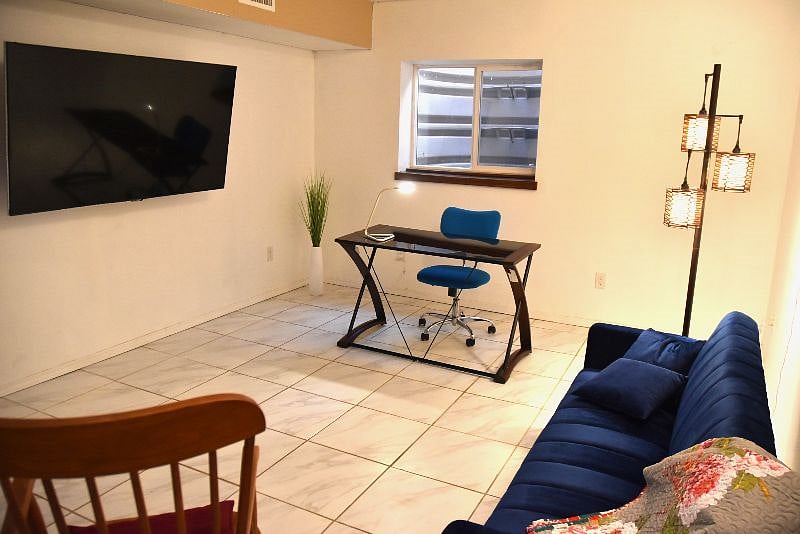 Living area located in basement with wall-mounted Wi-Fi enabled TV