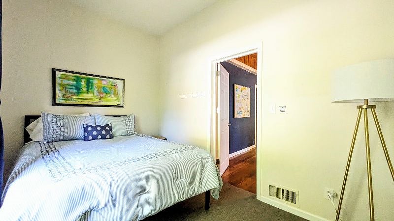 Main level Bedroom with plush queen bed, new linens, wardrobe and blackout curtains