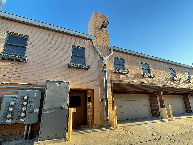 Back door to building that leads to elevator. Parking space is first garage. Windows of unit are on second floor.