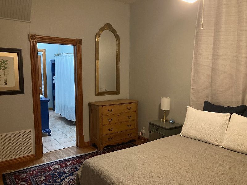 Downstairs master bedroom features high ceilings, ceiling fan, and plenty of storage