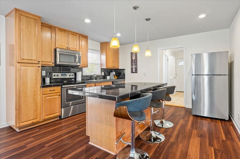 Renovated kitchen with Stainless appliances, and large island with 3 bar stools
