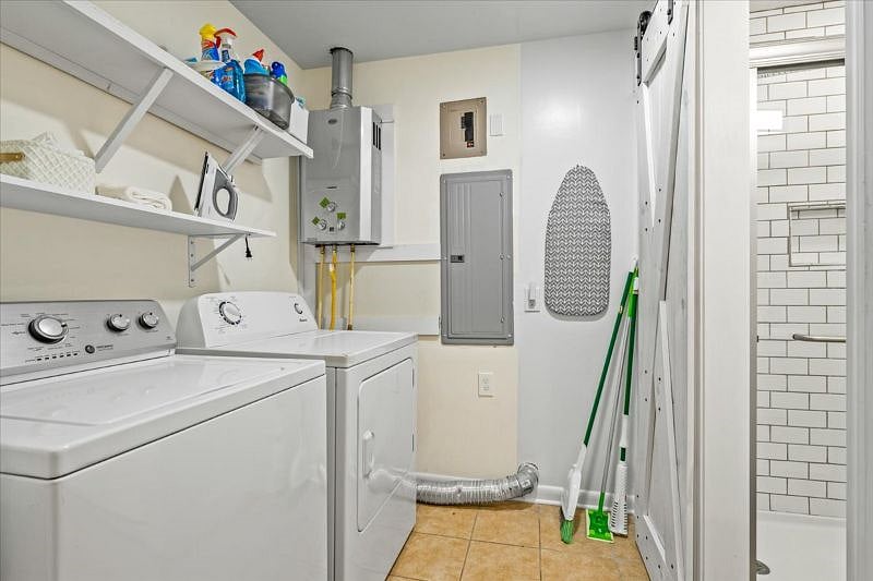 Newly added laundry room with full sized washer dryer, iron and iron board
