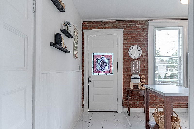In this photo the 1st floor hallway is behind you. Kitchen pantry closet is through the door on the left which contains a stackable washer and dryer and pantry storage for food, cleaning products, etc. The beautiful stained glass pictured is in the backdoor that leads out to an elevated screened-in back porch.