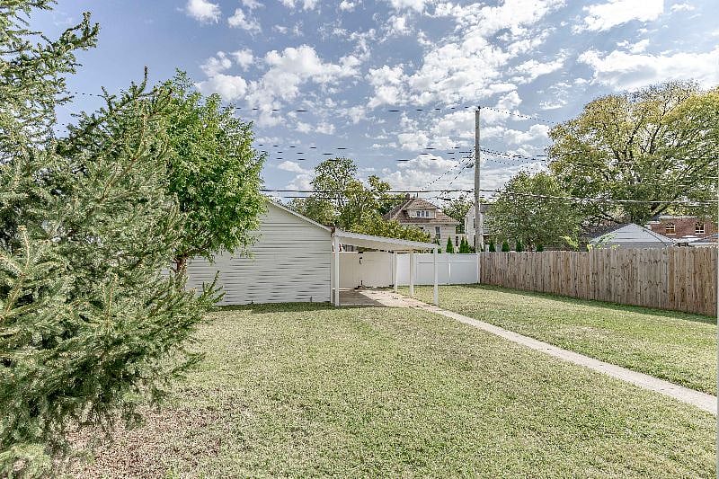 Left side of backyard picturing garage and carport.