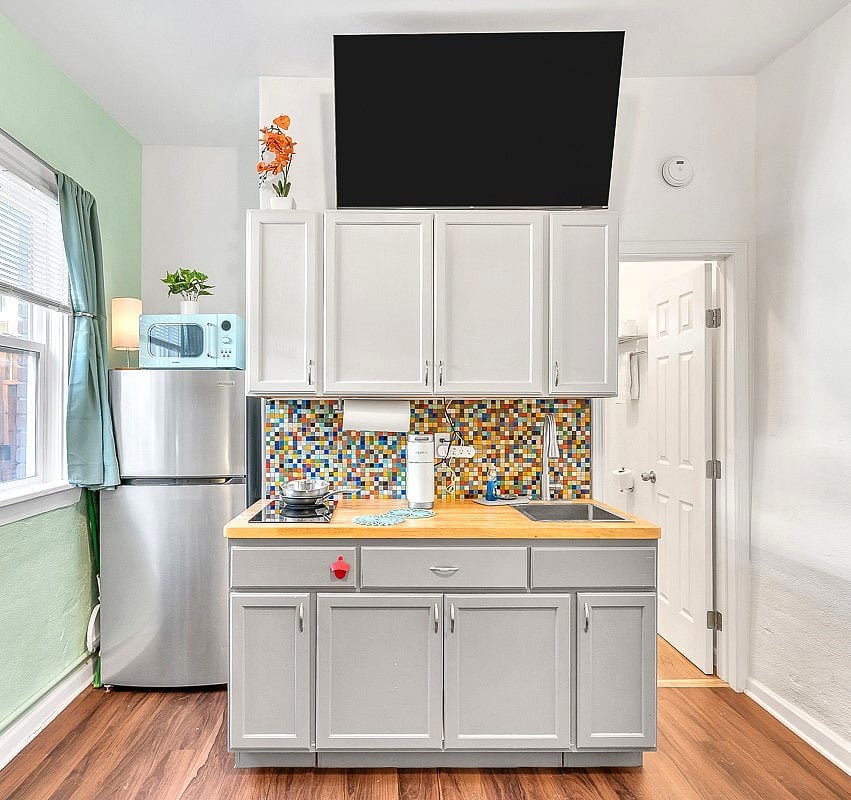Small but functional and stylish kitchenette with conduction cooktop, microwave, pots, pans, knives, utensils, silverware, glassware and coffee mugs, generous refrigerator (not a mini), 55" smart TV, nice natural light with window to your private entryway.