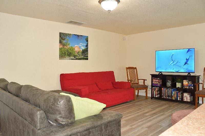 Family room with a queen sized futon, large smart TV, books, games, and toys.