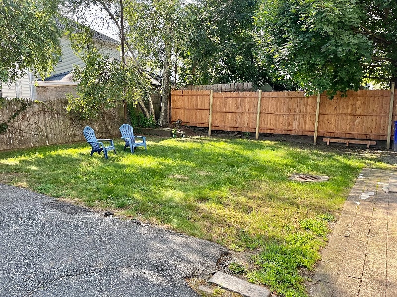 Partially fenced yard for relaxing or exercising a small pet.