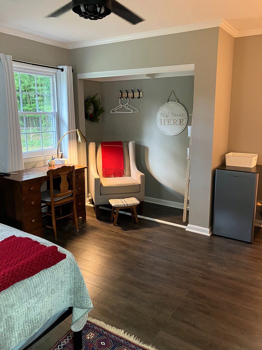 Desk overlooking backyard and sitting area with small fridge for personal snacks.
