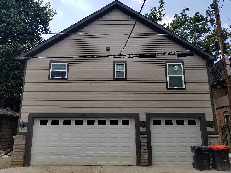 View from the alley of the Carriage House that sits above the 3-car garage. The private parking for this unit is the single garage door on the right.