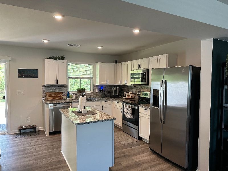 Fully stocked kitchen including air fryer, smoothie maker, and toaster. Dining nook/work space in left corner.