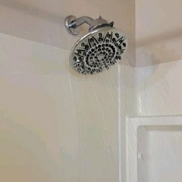 Bath and tub combo with a large shower head in the main bathroom