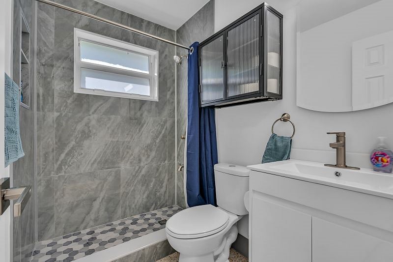 Bathroom newly renovated with plenty of storage for toiletries. Hair dryer and clothing steamer included.
