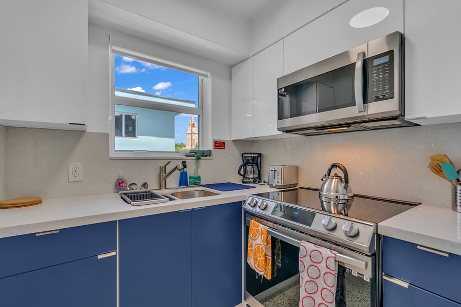 Full Kitchen with coffee maker, blender, microwave, full size fridge, utensils, cookware, glassware