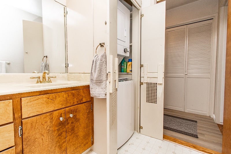 Bathroom with washer and dryer in cabinet.