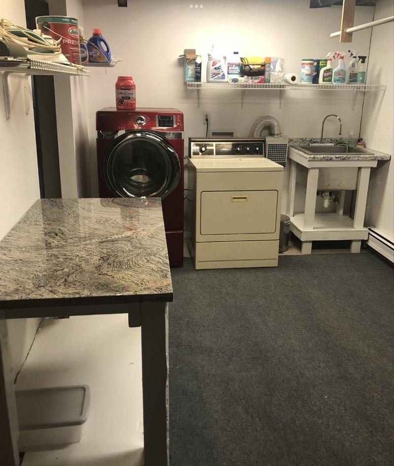 Downstairs laundry area with utility sink, folding table and clothes hanging rod