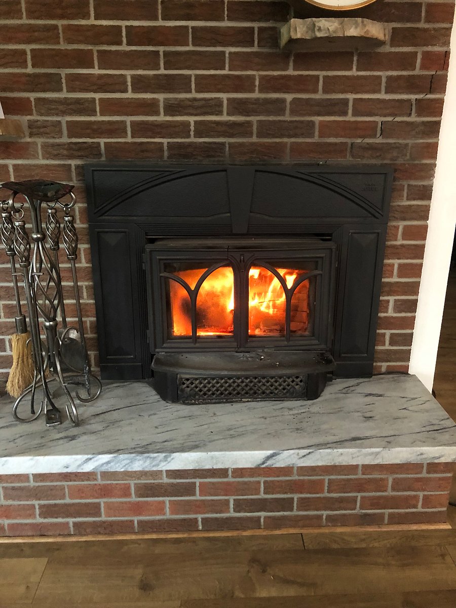 Wood insert fireplace in living room. Wood is provided for your use.