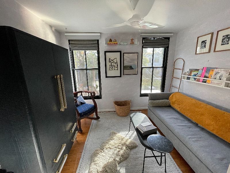 Second bedroom - queen sleeper sofa, storage shelving, & large armoire. View to the courtyard from two front facing windows.
