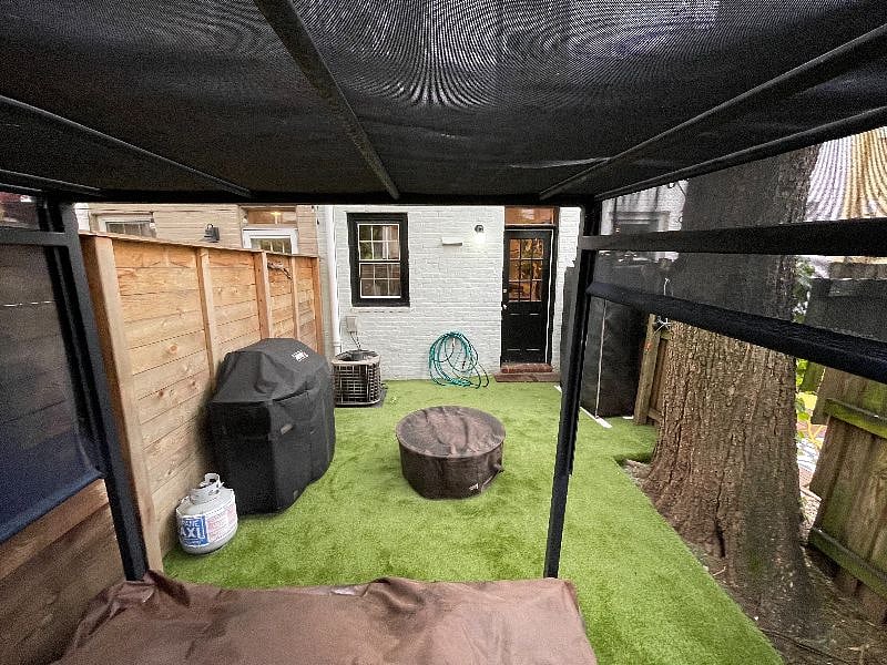 View looking back to the house from outdoor furniture, grill is available for guest use.