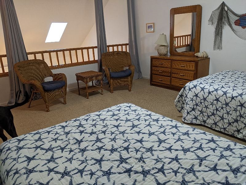 Loft bedroom overlooking living area and screen porch