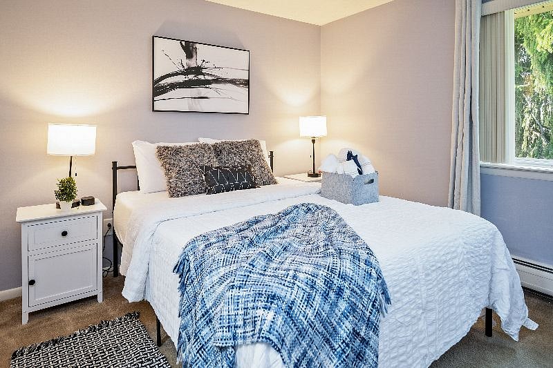 Welcome to our spacious bedroom, perfectly designed for your comfort and convenience. Enjoy the best of both worlds with room darkening shades that allow you to control the natural light flooding through our large windows, highlighting the inviting queen size bed. With a generous closet covering a storage-laden shelf, we ensure that every aspect of your stay is thoughtfully taken care of.
