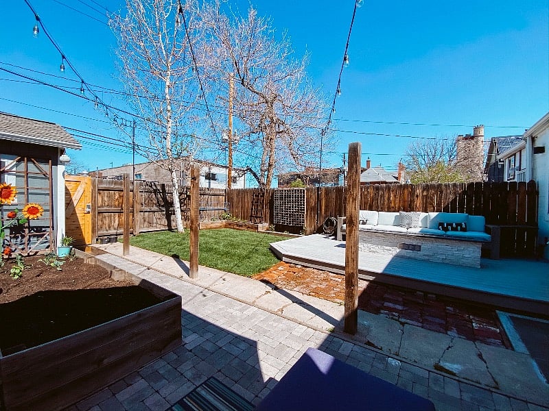 Share backyard including garden beds and a gas fire pit.
