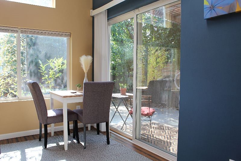 light-filled dining table with lots of windows, sliding door, and skylight
