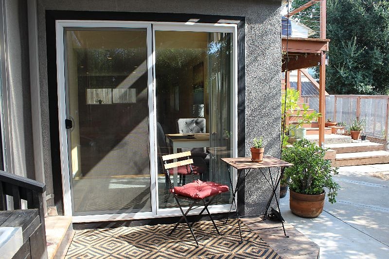 private deck that leads to a shared backyard and garden