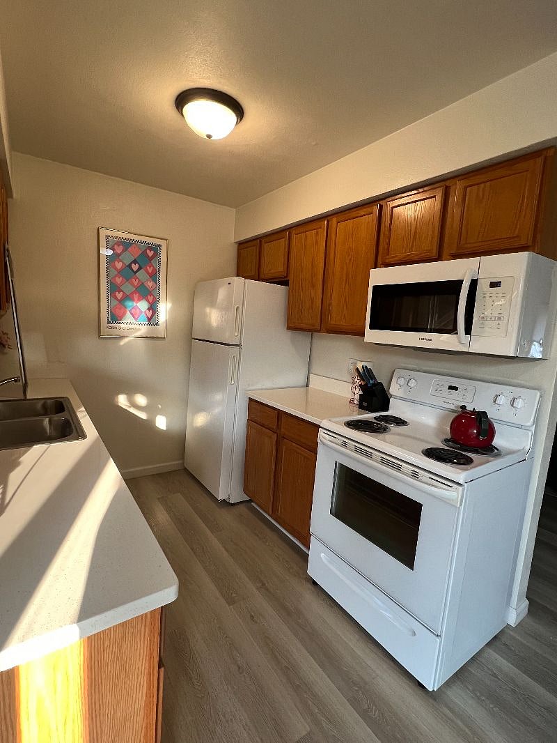 Kitchen space includes a double-sided sink with a garbage disposal, stove and oven, microwave, full-sized fridge and freezer, dishwasher and lots of cabinet space.