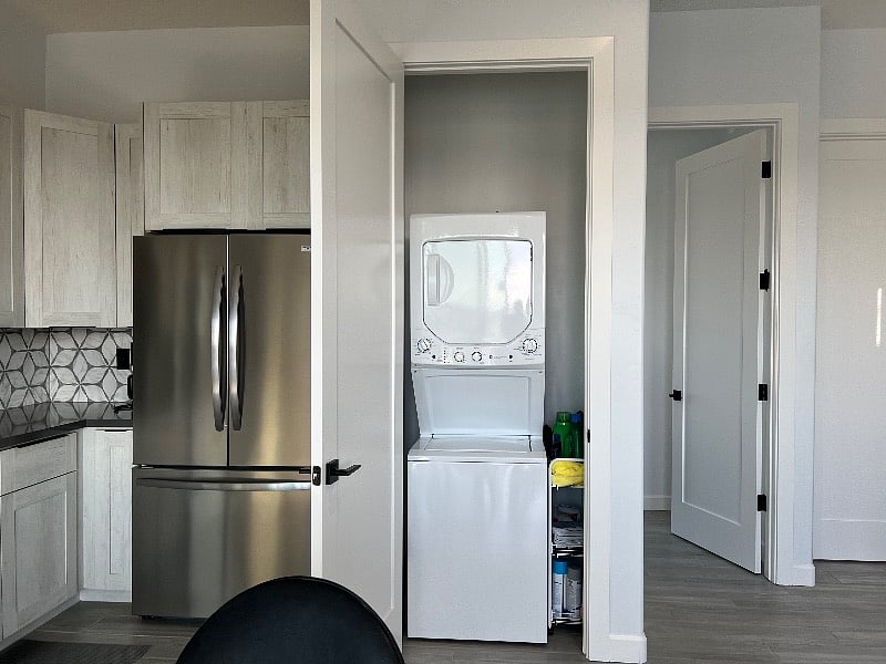 stacked washer and dryer behind cupboard doors