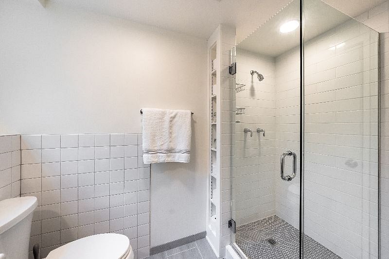 Glass door tiled shower.