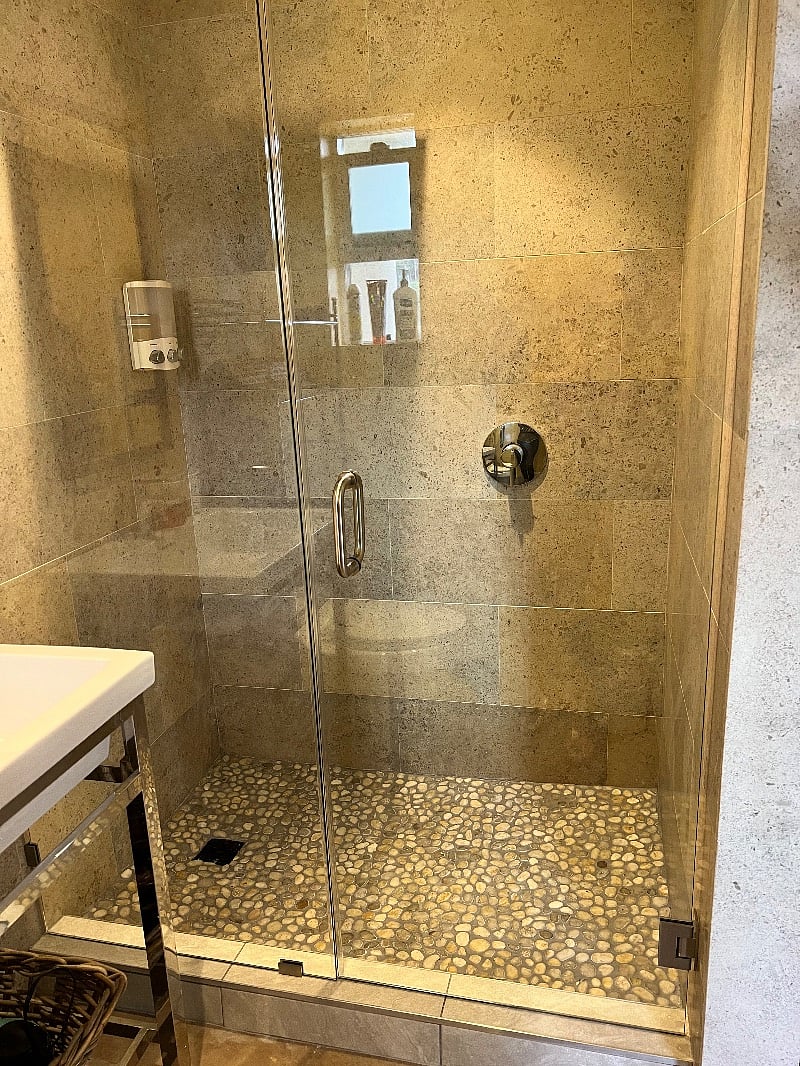 Nice sized rain shower with spa like pepple floor and glass shower wall
