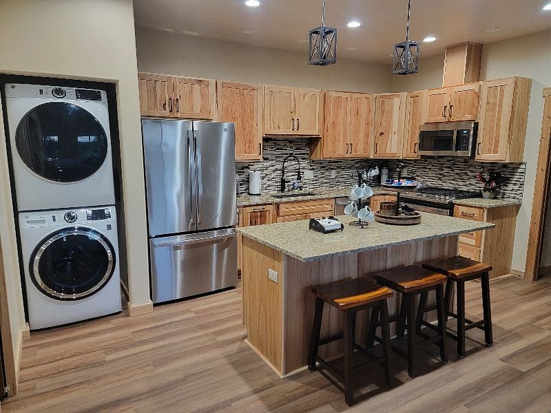 View of full kitchen and washer / dryer.