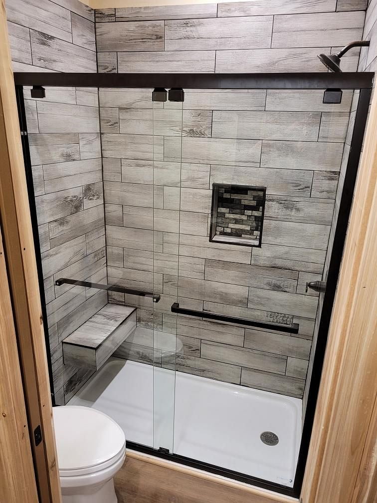 The shower and toilet area of the bathroom.  Has a pocket door for privacy from the double vanity area.