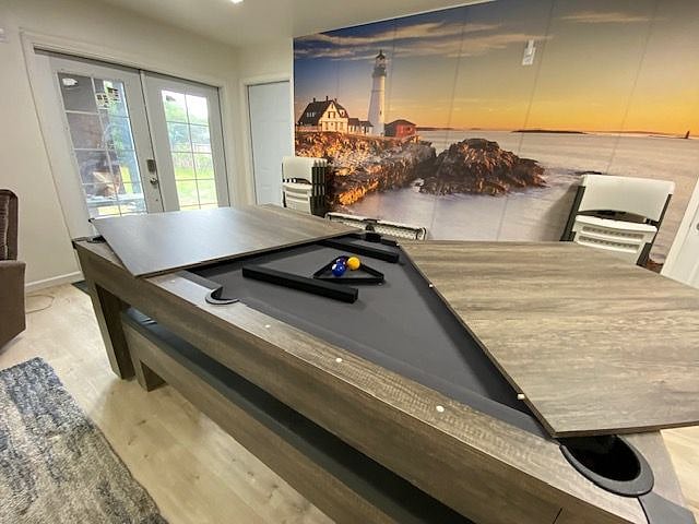In the living room, a large table that converts to a pool table or ping pong table.