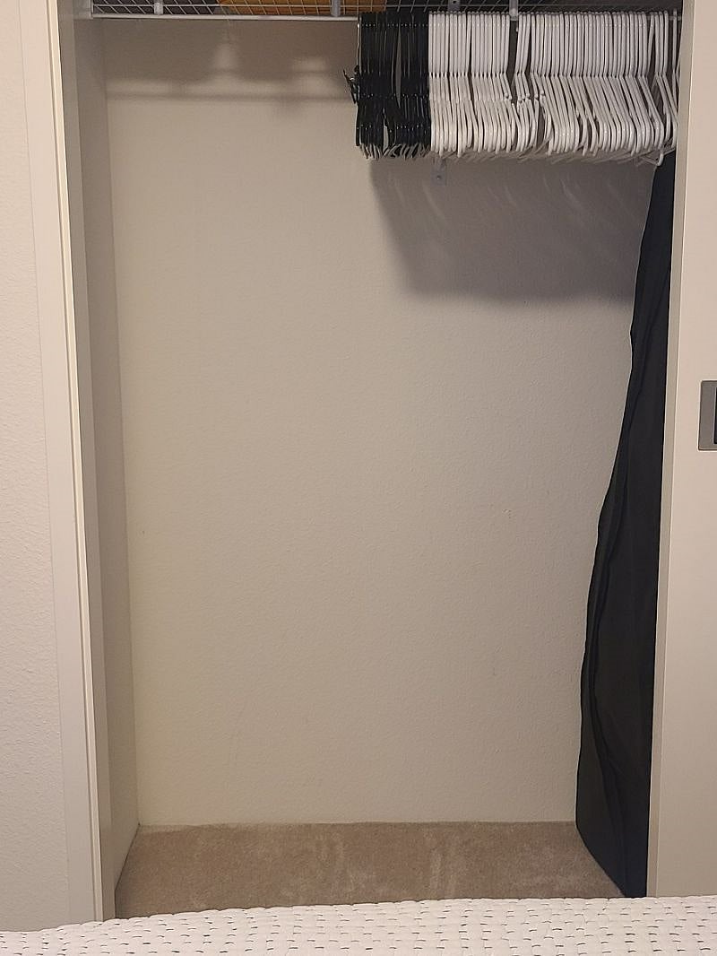 There's half a closet area for hanging clothes and personal belongings.